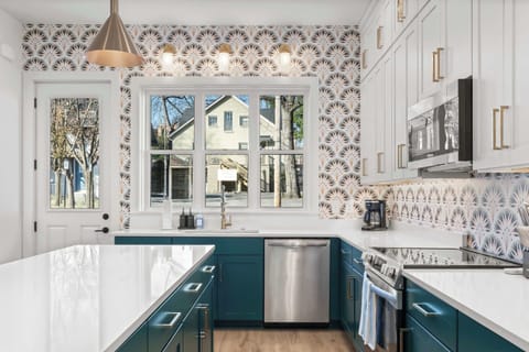 Bright, designer kitchen with a large island, quartz countertops, custom cabinetry, and beautiful natural light from oversized windows.