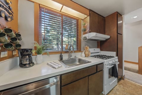A warm, wood-accented galley kitchen with generous prep space and a charming cabin feel.