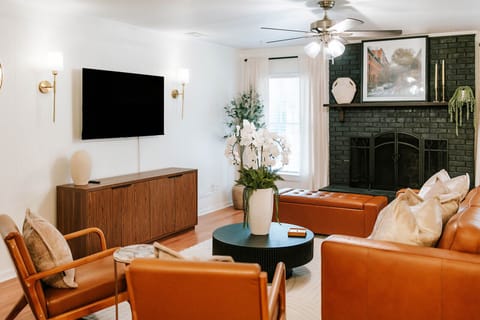 Bright, open living area centered around cozy seating and a statement fireplace.