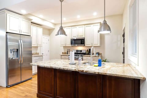 Spacious gourmet kitchen featuring granite countertops, stainless steel appliances, and a large center island perfect for cooking or gathering.