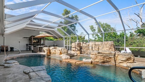 Resort-style pool with built-in hot tub and rock waterfall