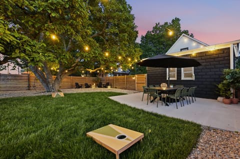 Your own slice of backyard bliss — string lights, a blooming magnolia, and a fully fenced patio made for long dinners and easy evenings under the Indy sky.