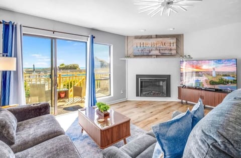 Beautiful living room: big TV, electric fireplace, deck views, USB/C plugs, queen pullout sofa.