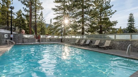 Dive into sunlit mountain serenity beside the sparkling outdoor pool.