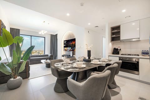 Warm, open-concept room with a full kitchen and elegant dining setup—made for memorable stays