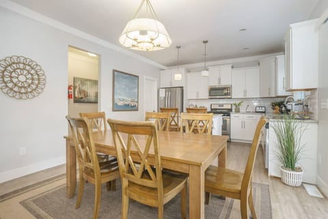 Dining room with seating for eight, flowing seamlessly into a bright, fully equipped kitchen.