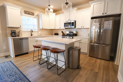 This bright, fully stocked kitchen makes cooking on vacation a breeze. Spacious center island with seating for three, stainless- steel appliances, and plenty of counter space for preparing meals or gathering with family.