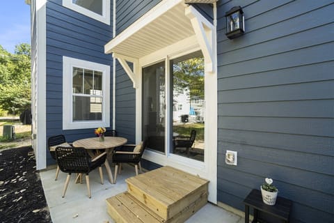 Charming private patio with comfortable seating, a cafe-style table. and easy access through the sliding doors.