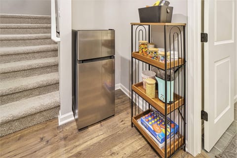 This cozy basement landing features a handy mini-fridge and stocked snack shelf, perfect for late-night treats or easy grab-and-go options during your stay.