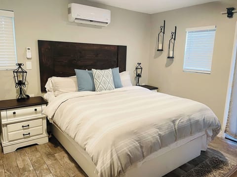 This gorgeous guest room is a private oasis, featuring a stunning dark wood headboard, stylish distressed nightstands, and soft, high-quality linens. Enjoy customized comfort with the dedicated AC/heating unit and charming ambient lighting.