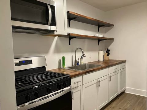 This charming kitchen comes with a full set of modern appliances, from a stove to a microwave and refrigerator.