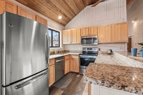 Kitchen area with table and breakfast bar area overlooking the large deck and pond