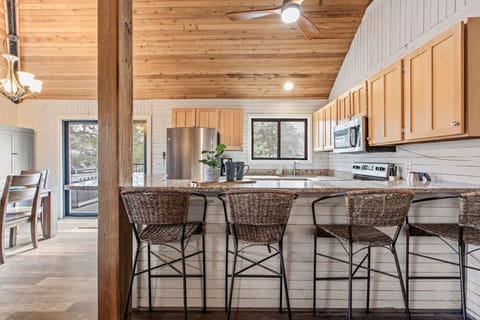 Kitchen area with table and breakfast bar area overlooking the large deck and pond