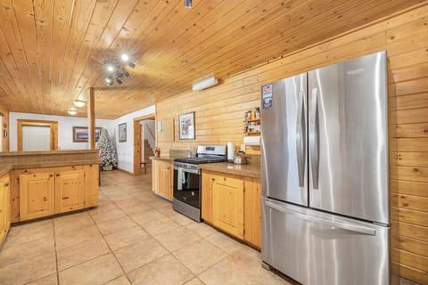 Fully stocked kitchen with rustic charm, stainless appliances, and ample space.