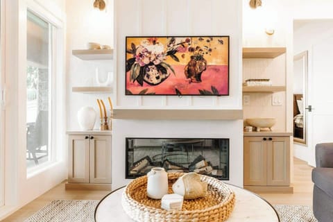 
The living room features a cozy setup with a TV and fireplace, complemented by a stylish round coffee table, creating a warm and inviting atmosphere.