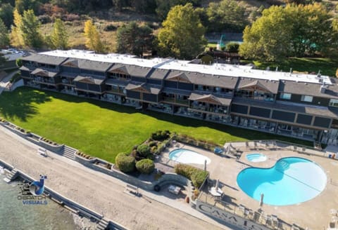 Aerial shot focusing on the resort's sparkling swimming pool, surrounded by beautiful structures and greenery.
