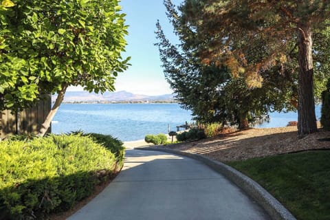 Paved path leading to a body of water, with a stunning mountain view in the distance, perfect for scenic walks