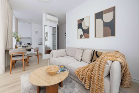 A bright lounge area with a soft sofa, natural fabrics and warm accents creates a comfortable space to unwind after a busy day.