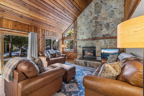 Sink into plush leather seating by your crackling stone fireplace, where warm wood surrounds you in mountain comfort.