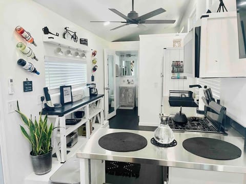 Ideal for quick meals or snacks, this charming kitchenette offers a compact stovetop, essential prep space, and clever storage solutions, including built-in wine and mug racks, ensuring all your needs are met in one functional space.