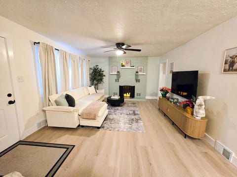 Living room with oversized couches, fireplace with remote control candles, TV