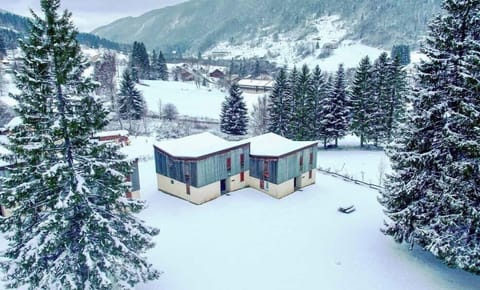 A charming lodge sits peacefully in the winter wonderland of Lélex, surrounded by majestic mountains and fresh snowfall.