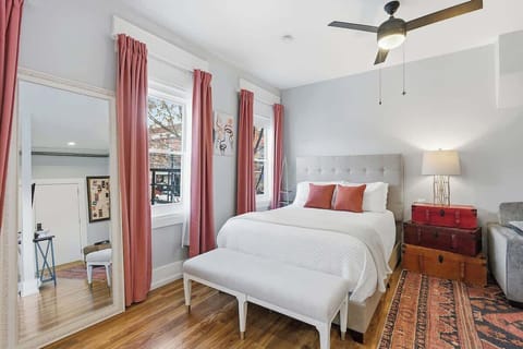 A comfortable sleeping area with a queen bed, full-length mirror, and soft natural light. Designed for a restful stay with everything you need within easy reach.