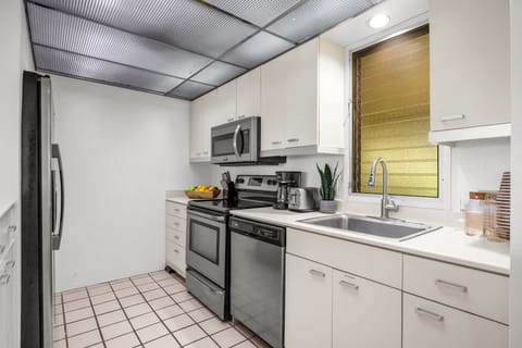 Clean, functional kitchen featuring white cabinetry, stainless appliances, and generous workspace designed for everyday island living