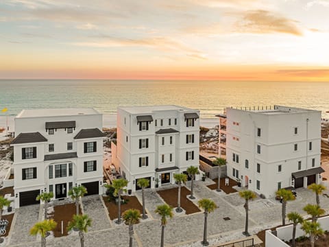 Beachfront property complex showcasing modern architecture with direct ocean access and stunning sunset views.