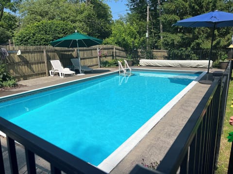 Large in-ground pool w/ shade umbrellas & stairs for easy going in & out of pool