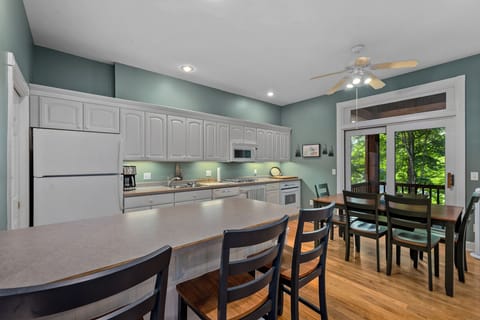 Bright lower-level kitchen with bar seating and dining area – the second full kitchen features modern appliances and plenty of space for meal prep.