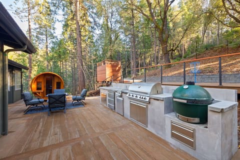 Outdoor kitchen with dual decks. Sauna, outdoor shower and hot tub also pictured.