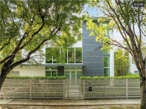 Modern home exterior surrounded by mature trees and lush landscaping