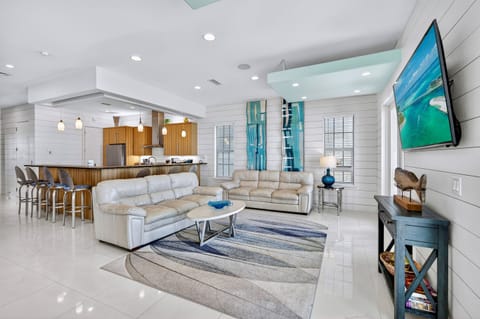 2nd Floor - Spacious Gulf-front great room with expansive ocean views, plush lounge seating, and direct access to a private balcony—perfect for relaxing, gathering, and taking in unforgettable sunsets over the emerald Gulf waters.