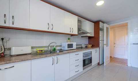 Modern kitchen with white cabinetry, granite counters, and stainless appliances. Bright, organized layout offers a clean, functional space.