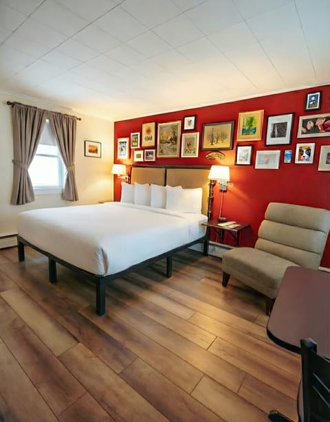 A bright bedroom with one king bed, crisp white linens, and a convenient in-room kitchenette.