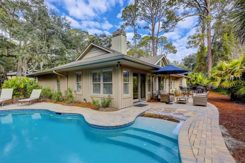 Backyard featuring a hot tub, pool, gas grill. and lots of lounging and sitting areas.