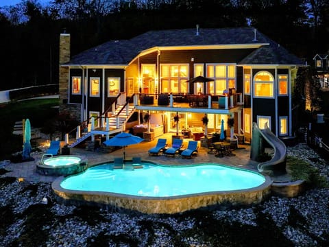 Resort-style pool + built-in spa with baja shelves, loungers in the water, and full lake views.