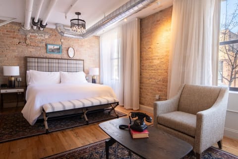 Unwind in a sunlit loft bedroom with exposed brick charm.