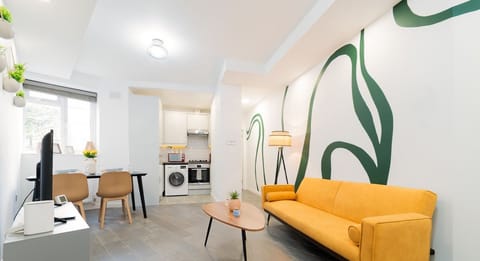 Open-plan living area with a double sofa bed, TV and dining space. The kitchenette includes an oven, washing machine and cooking essentials for your stay.