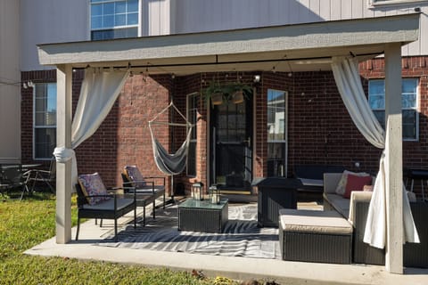 Cozy covered patio with a hammock and stylish seating.
