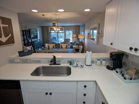 Kitchen view into sitting area, dining area, family room, and slider to balcony