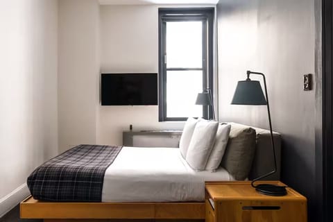 Unwind in a sleek, sunlit room with plush bedding.