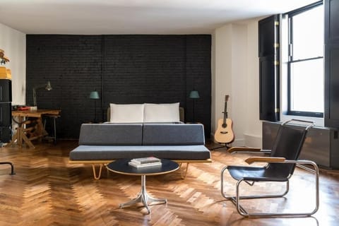 Unwind in a design-forward bedroom with sunlit hardwood floors.