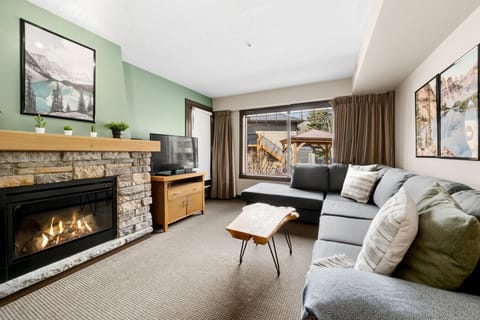 A cozy living area that seamlessly flows into a private patio, featuring outdoor seating, creating an inviting retreat for relaxation and entertaining.