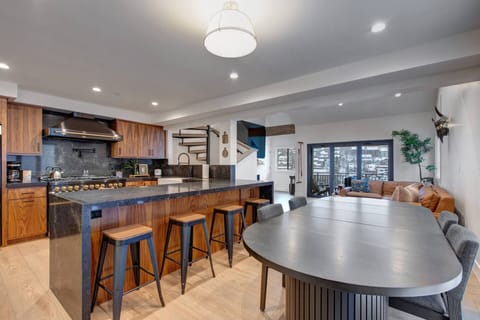 Your open-concept kitchen flows seamlessly into the dining area, where warm wood tones and sleek countertops create the perfect space for cooking and gathering together.