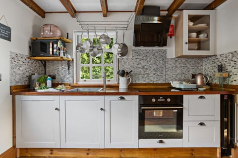 Kitchen area with hob and oven, microwave and slim dishwasher - Beryas Cottage