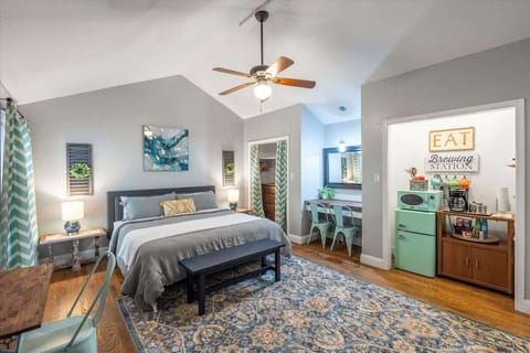 Inside of the Yellow Door Suite! King bed, closet with dresser, desk/eating area/kitchenette with fridge, microwave, hot plate and drip coffee maker