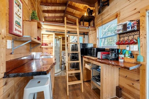 Tiny living at its finest! The king size bed is in the loft. You'll have to climb up the ladder to get to the bed. Not suitable for children under 5, elderly people, anyone with a fear of heights or claustrophobia.