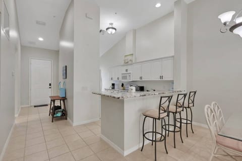 An eating bar with 3 bar stools separates the kitchen from the main living space.